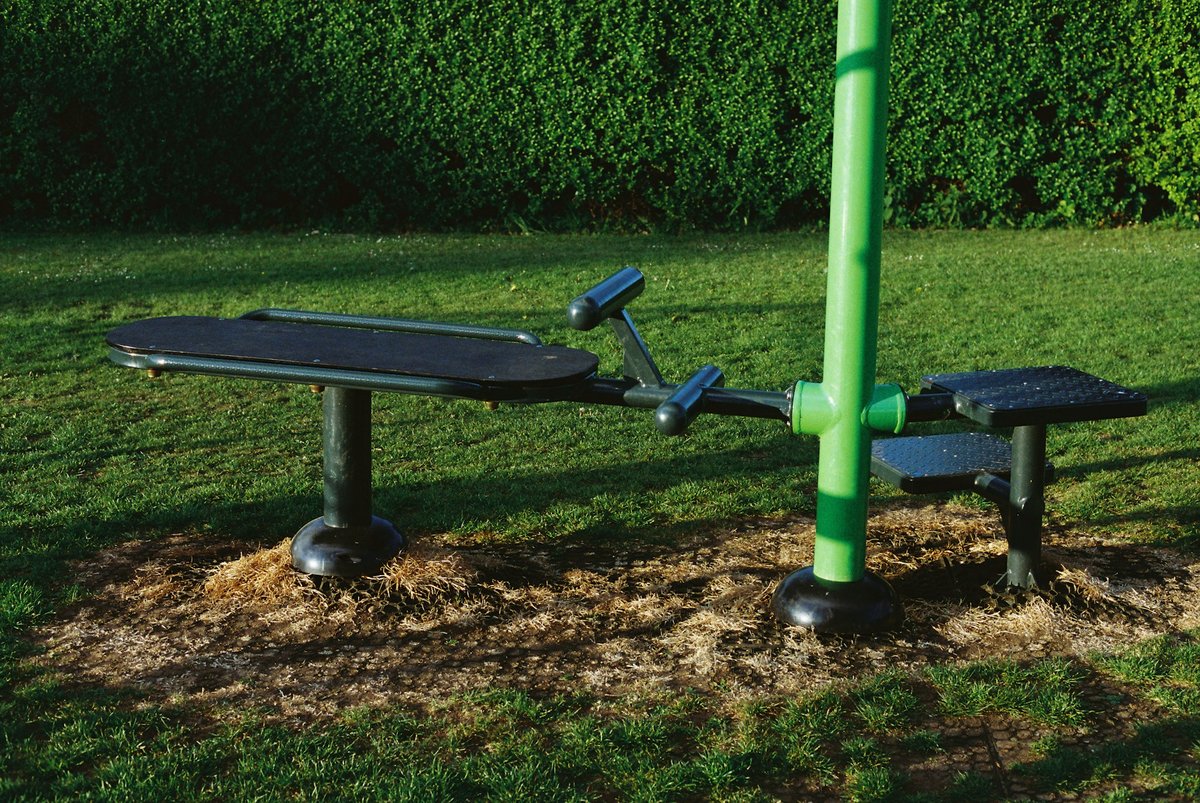 Banc d'exercice en plein air posé sur une pelouse, sans personne